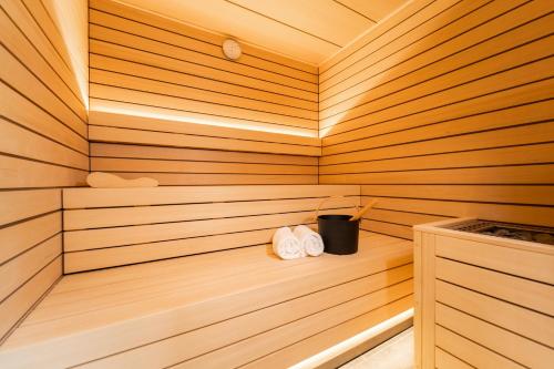una sauna con 2 toallas blancas y un cubo negro en Hôtel du Glacier, en Champex