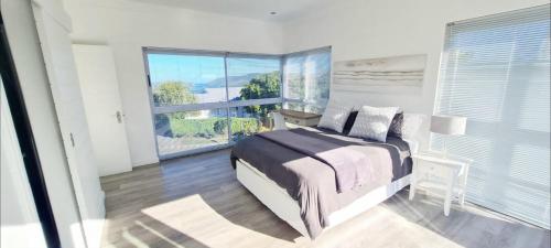 a bedroom with a bed and a large window at Strode House in Knysna