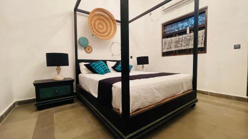 a bedroom with a four poster bed in a room at Flamingo Village in Jaffna