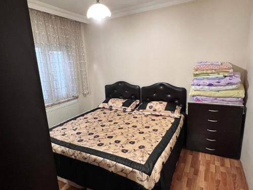 a bedroom with a bed and a dresser at TOPCU HOME in Akcaabat