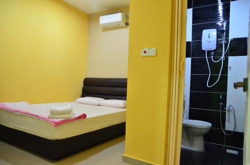 um pequeno quarto com uma cama e um WC em Deena Hotel Bajet em Gua Musang