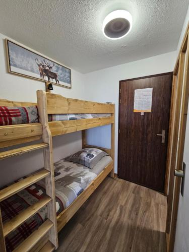Cette chambre comprend 2 lits superposés et une porte. dans l'établissement LES BALCONS DU SOLEIL L OURSON, à Font-Romeu-Odeillo-Via