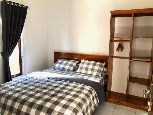 1 dormitorio con cama y estante para libros en LOPE HOMESTAY, en Ndangu