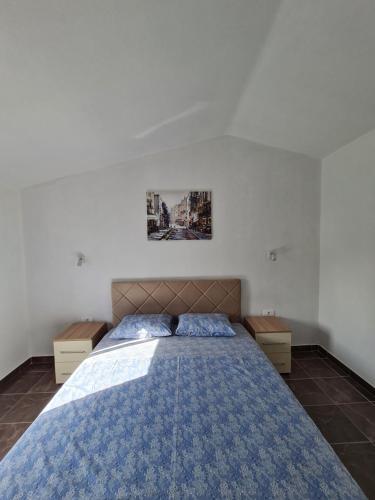 a bedroom with a large bed with a blue blanket at Demir Apartmani in Donji Štoj