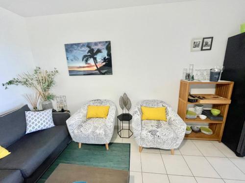ein Wohnzimmer mit einem Sofa und 2 Stühlen in der Unterkunft Kazalena in Saint-Pierre
