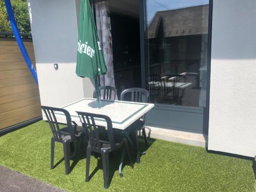 a table with chairs and an umbrella on a patio at Appartement au cœur de la Savoie in Saint-Jean-de-la-Porte