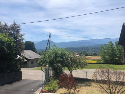 a view of a house with mountains in the distance at Appartement au cœur de la Savoie in Saint-Jean-de-la-Porte