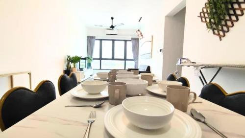 a long table with white bowls and plates on it at De Luma - Meritus in Perai