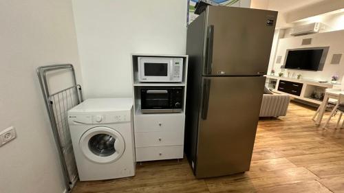 La cuisine est équipée d'un réfrigérateur, d'un four micro-ondes et d'un lave-linge. dans l'établissement Shimshon By The Sea, à Tel Aviv