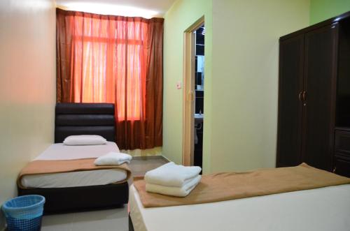 a small room with two beds and a window at Deena Hotel Bajet in Gua Musang