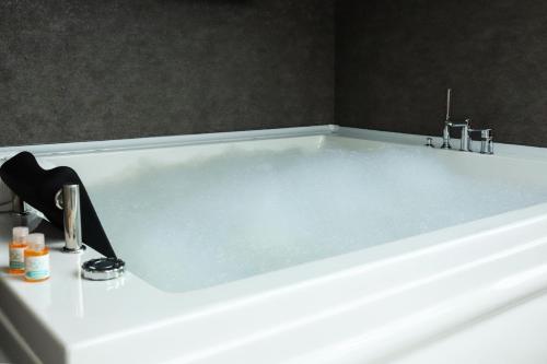 a white bath tub with a sink in a bathroom at Melissa Suite in Trabzon