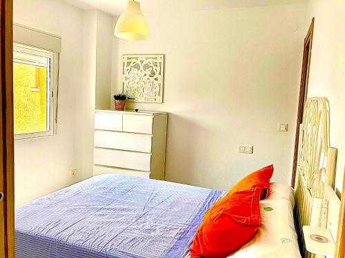 een slaapkamer met een bed met rode kussens bij Apartamento Vistas al mar in Algarrobo-Costa