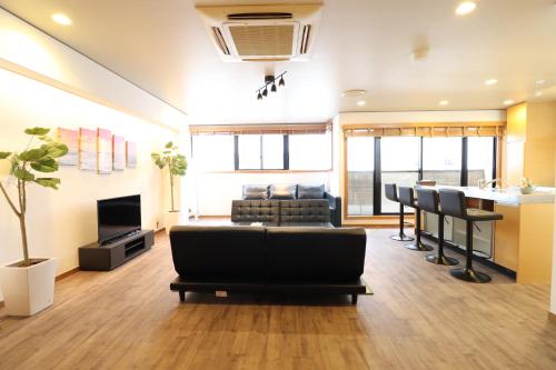 a living room with a couch and a bar at Crane Court KitaHorie in Osaka