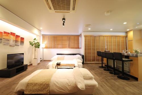 - une chambre avec 2 lits, un bureau et une télévision dans l'établissement Crane Court KitaHorie, à Osaka