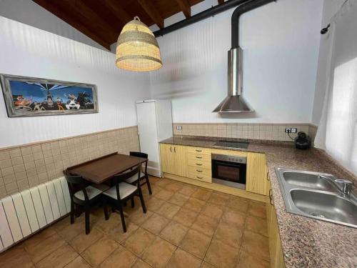 a kitchen with a table and a sink in it at Molinet in Santa Eulalia de Ronsaná