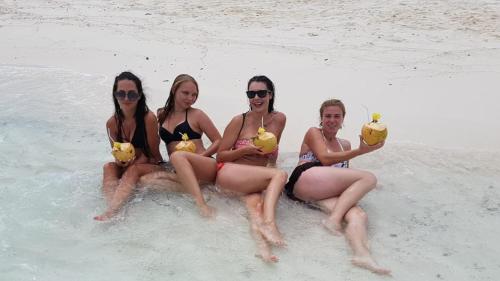 a group of four women sitting in the water at Batuta Maldives Fourson in Thulusdhoo