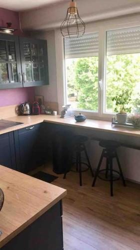 a kitchen with a large counter and two windows at Bord de Loire - Île de Nantes (parking inclus) in Nantes