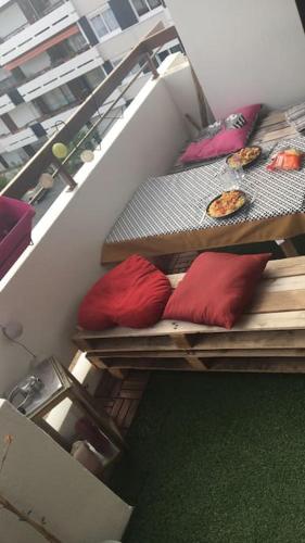 a balcony with three beds with red pillows on it at Bord de Loire - Île de Nantes (parking inclus) in Nantes