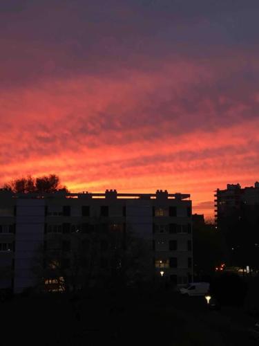un coucher de soleil dans une ville avec un ciel rouge dans l'établissement Bord de Loire - Île de Nantes (parking inclus), à Nantes