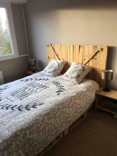 - une chambre avec un grand lit et une tête de lit en bois dans l'établissement Bord de Loire - Île de Nantes (parking inclus), à Nantes