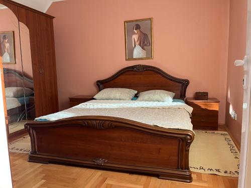 a bedroom with a large wooden bed with two pillows at Luxury Apartment in Mladenovac