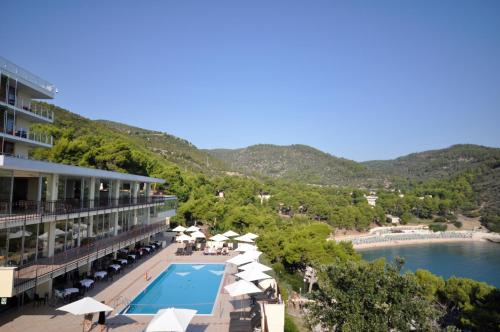 ヴィエステにあるPugnochiuso Resort Hotel del Faroのプールとビーチのあるホテルの景色を望めます。