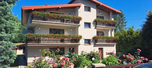 un bâtiment avec des boîtes de fleurs sur ses balcons dans l'établissement Apartament Rycerka Górna, à Rycerka Górna