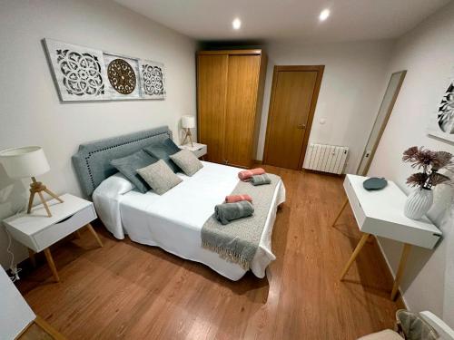 Schlafzimmer mit einem großen weißen Bett und Holzböden in der Unterkunft Apartamento Lujo centro histórico in Valladolid