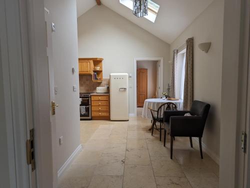 a kitchen with a table and a white refrigerator at Little Chilsbury in Potterne