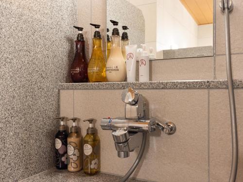 a bunch of bottles sitting on a shelf in a bathroom at La'gent Hotel Kyoto Nijo in Kyoto