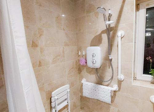 a shower with a shower head in a bathroom at Farm View Cottage Castlerea in Castlerea