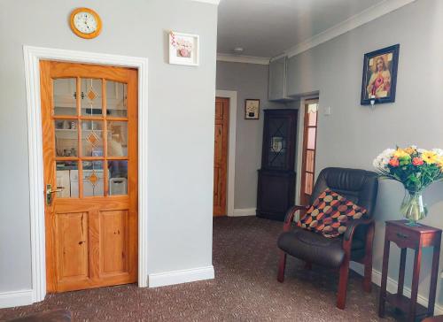 a room with a door and a chair and a vase of flowers at Farm View Cottage Castlerea by Trident Holiday Homes in Castlerea