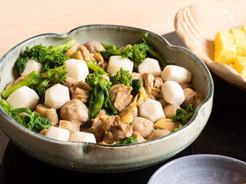 a pan of food with broccoli and mushrooms on a table at La'gent Hotel Kyoto Nijo in Kyoto