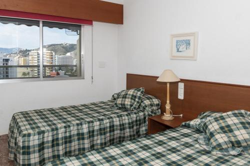 una camera d'albergo con due letti e una finestra di Florazar 2, Vi-10-B a Cullera