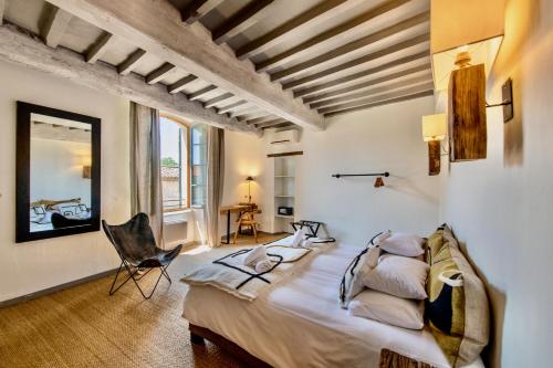 1 dormitorio con 1 cama grande y 1 silla en Au Ralenti du Lierre, en Beaumettes
