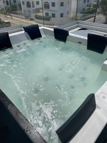a large pool of water with chairs in it at By the Beach Villa 7 in Protaras