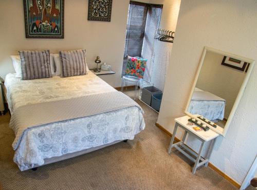 1 dormitorio con cama y espejo grande en Stay @ Honeytree, en Edenvale