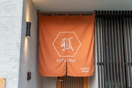 an orange sign on the side of a building at Irodori Hotel KITSUNE in Fukuoka