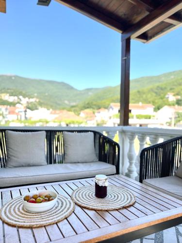 a table with a bowl of fruit on a balcony at Apartman Misovic in Herceg-Novi