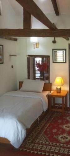 a bedroom with a bed and a table with a lamp at Riverside Homes in Deorāli
