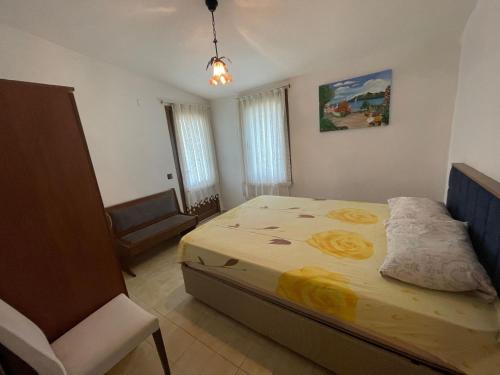 a bedroom with a bed and a chair in it at Huge Villa 300 meters to sea and near to Ida mount in Burhaniye