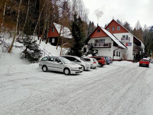 a group of cars parked on the side of a snow covered road at Penzion Lukáš in Malá Morávka