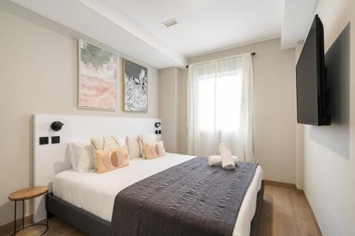 マドリードにあるDobo Madrid Cabreraのベッドルーム1室(大型ベッド1台、壁掛けテレビ付)