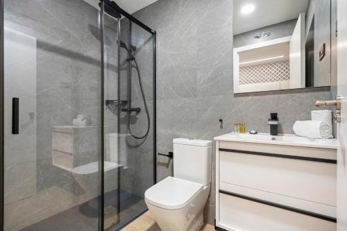 uma casa de banho com um chuveiro, um WC e um lavatório. em dobohomes - GC21 em Madri