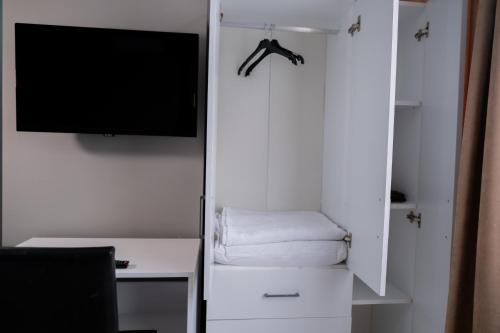 MY HOME IN TRABZON في طرابزون: غرفة مع تلفزيون وخزانة بيضاء مع مكتب
