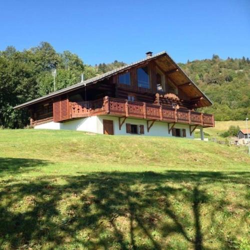 une maison avec un balcon au sommet d'une colline dans l'établissement Chalet SPA Le Royal Nathalie MN La rouge, à La Bresse