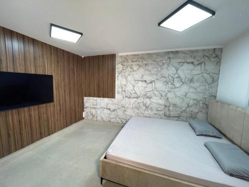 - une chambre avec un lit et un mur avec une télévision dans l'établissement סוויטה מפוארת 800 מטר מהים קיסריה, à Or ‘Aqīvāh
