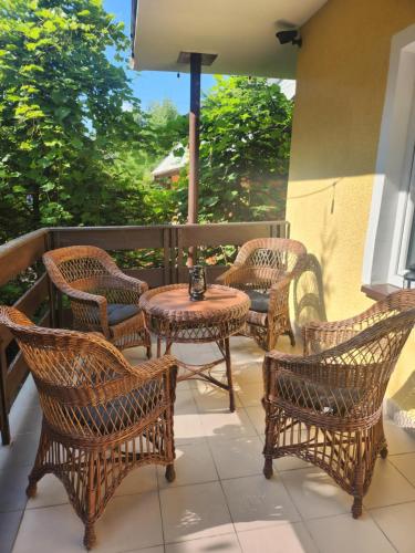 a group of wicker chairs and tables on a porch at Duży dom Wilkasy Zalesie 100m od plaży in Wilkasy