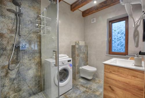 y baño con lavadora y lavamanos. en Chaty na Skalistym Wzgórzu en Solina