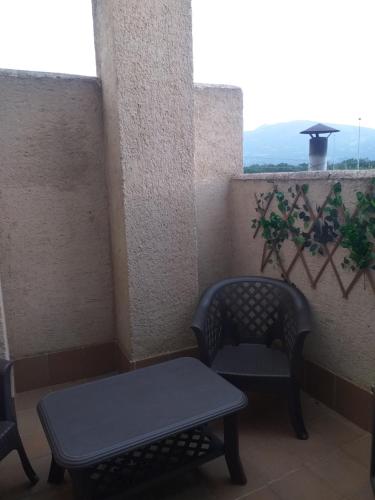 a balcony with two chairs and a table and a window at El Mondalindo Habitación intima con patio in Lozoyuela
